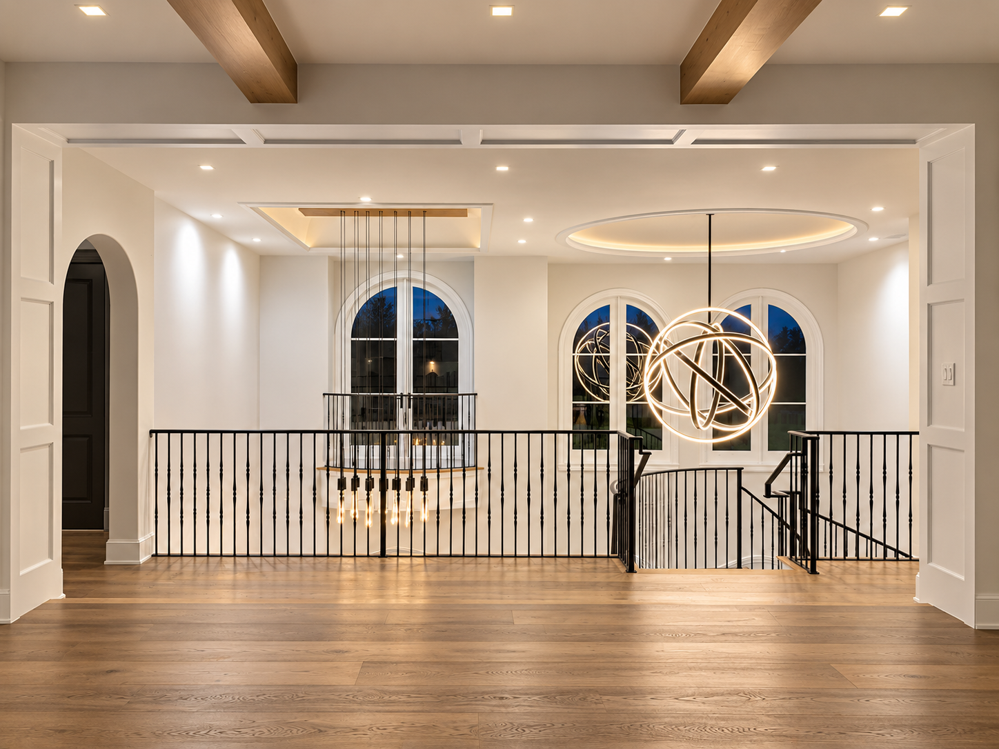 Residential mezzanine lit by an orb chandelier, filament-bulb pendants, and recessed ceiling lighting
